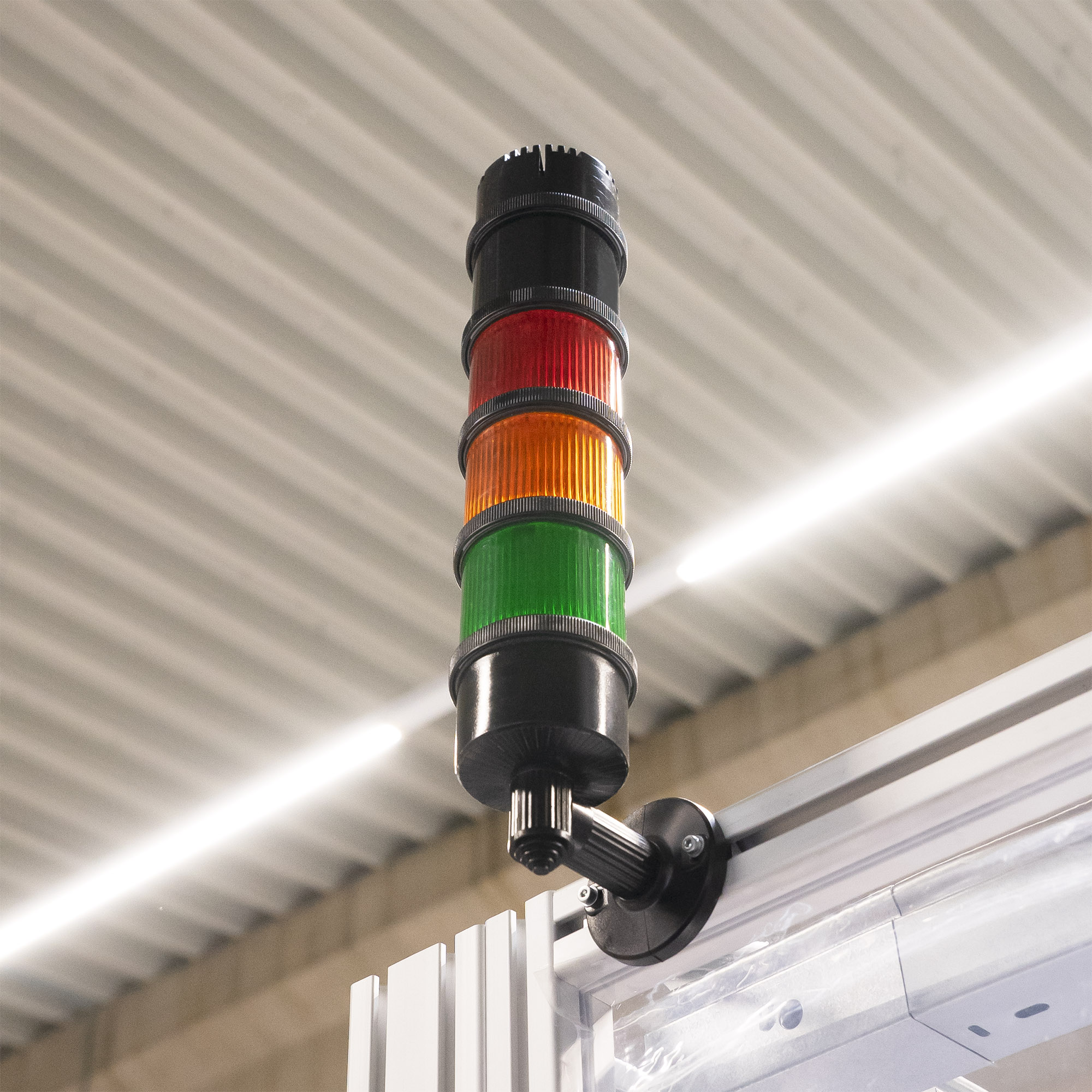 Zylindrische LED-Warn- und Blinkleuchte mit geriffelter grünfarbiger Abdeckung, schwarzem Sockel und Anschlussgehäuse