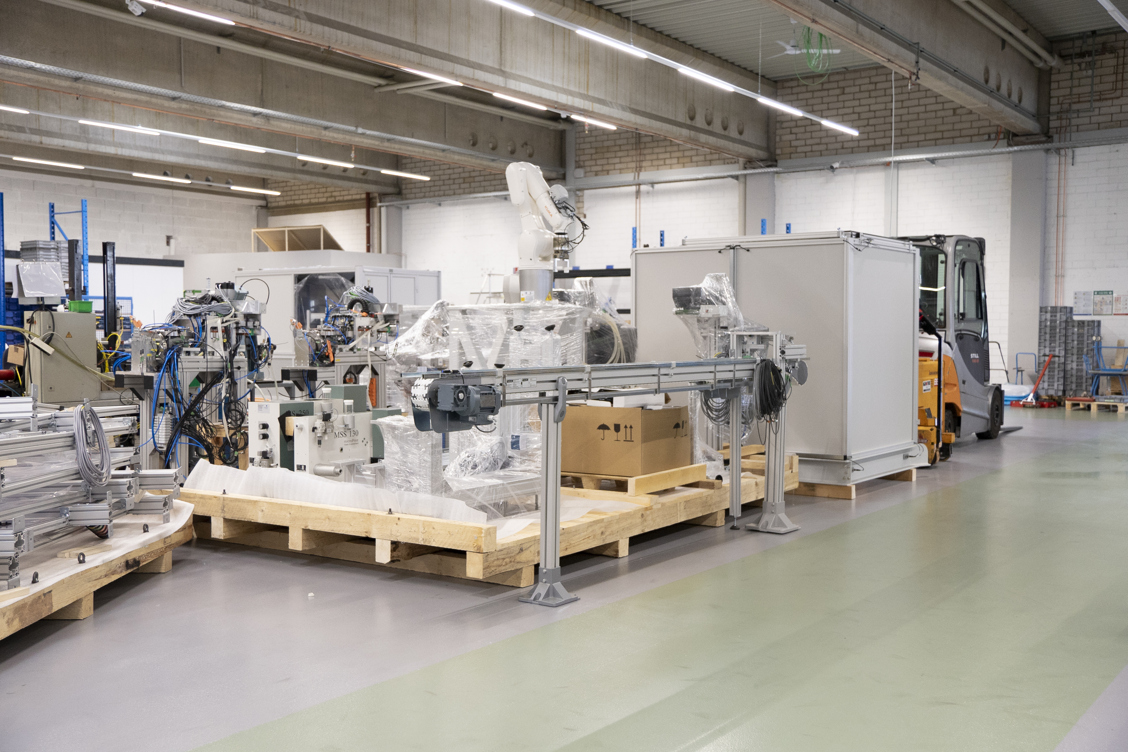 Die Teile der Maschine auf großen Paletten in der Produktionshalle