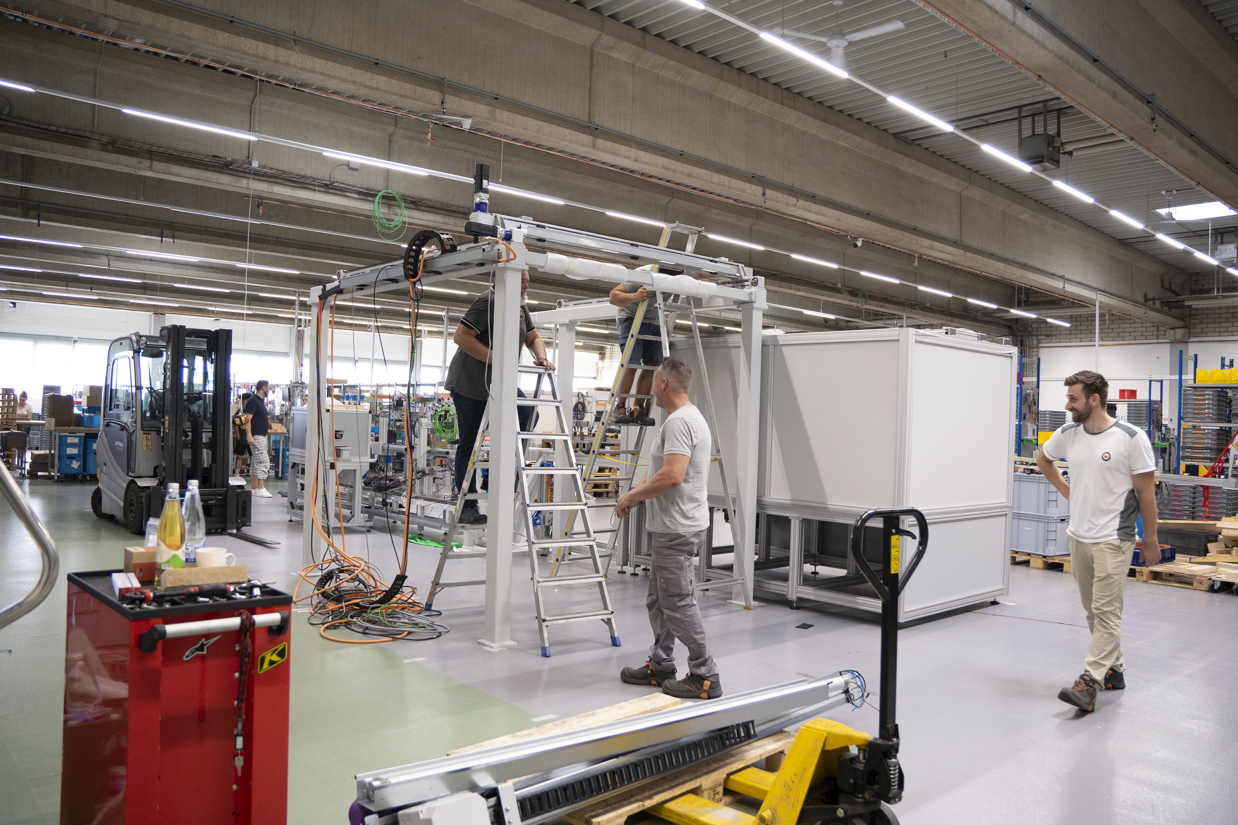 Drei MMTE-Mitarbeiter beim Aufbau der Maschine